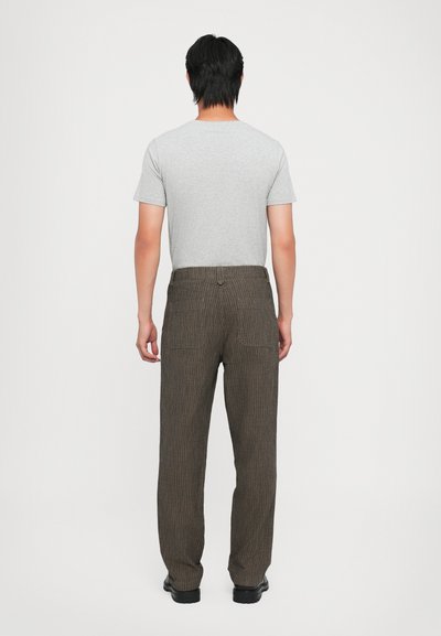 Gray t-shirt with short sleeves paired with brown striped corduroy pants, featuring two back pockets and a straight-leg design.