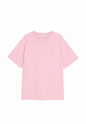 Lys rosa kortermet bomulls-T-skjorte med rund hals, ledig passform og liten merkelapp "OH APRIL" på innsiden av kragen.