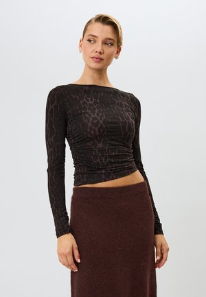 Top de manga larga en material negro con un patrón de piel de animal marrón, con fruncidos en la cintura. Textura suave y diseño ajustado.