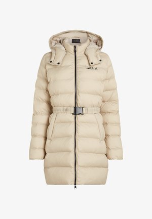 Beige pufferjack met ritssluiting, capuchon en een ceintuur om de taille. Heeft horizontale stiksels en een merkimprint op de borst.