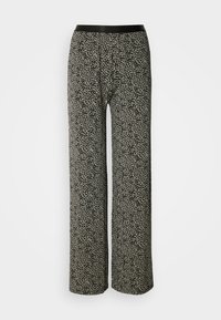 Pantalons à motifs noirs et crème avec une coupe large et une taille élastique. Le tissu a une apparence douce et texturée.