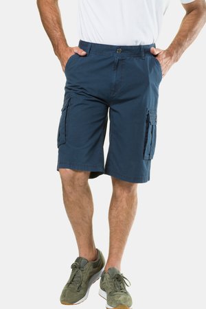 Mann trägt marineblaue Cargoshorts mit Seitentaschen und olivgrüne Sneakers, steht mit den Händen in den Taschen.