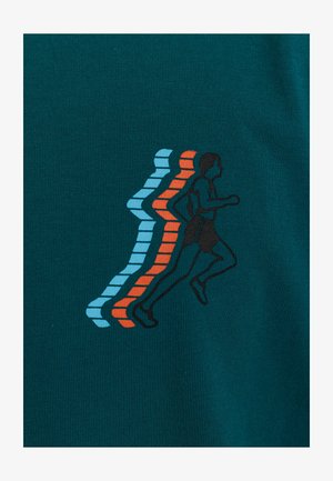 T-shirt de sport turquoise avec un tissu texturé, arborant un graphique d'une silhouette courante en noir, accompagné de lignes bleues et oranges suggérant le mouvement.