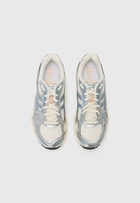 Ελαφριά παπούτσια sneakers σε λευκό διχτυωτό υλικό με ασημί λεπτομέρειες. Διαθέτουν μπλε ρίγες, στρογγυρούς κορδόνες και μαλακή σόλα για άνεση.