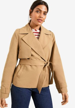 Beige Wickeljacke mit Reverskragen, tailliertem Gürtel und langen Ärmeln, aus strukturiertem Stoff und mit zwei Seitentaschen.
