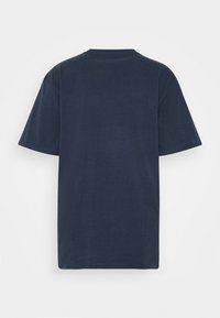 Camiseta de algodón azul marino con cuello redondo y mangas cortas. Textura suave con corte recto, sin logotipos ni patrones visibles.