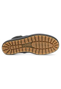 Suola di scarpa in gomma nera con motivo di battistrada; presenta dettagli marroni chiari e scanalature incassate per un miglior grip. Logo del marchio visibile.