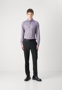 Light purple long-sleeve shirt with buttons, paired with black trousers and black shoes. Smooth fabric, tailored fit, and structured design.
