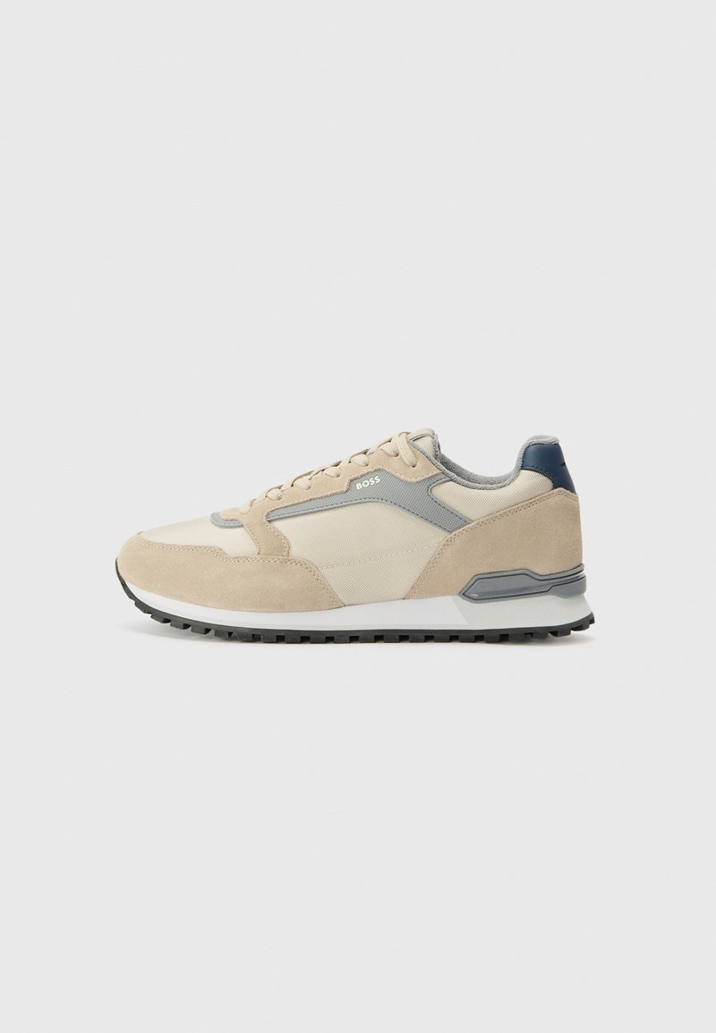 Baskets basses beige et gris clair avec laçage à l'avant, semelle texturée et logo "BOSS" sur le côté, présentées sur fond blanc.