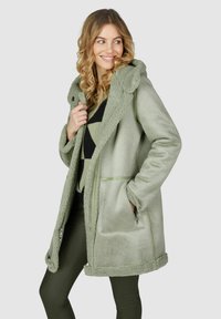 Lichtgroene fleece jas met een capuchon en nep bontafwerking. Voorzien van twee zijzakken en een ritsluiting, met een zachte textuur en een ontspannen pasvorm.