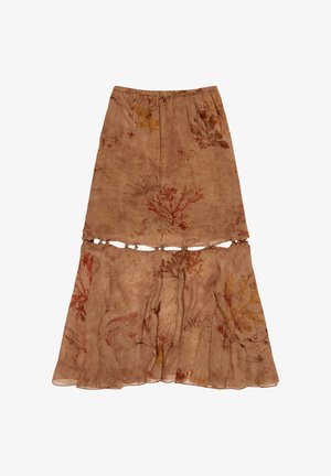 Brązowa półprzezroczysta spódnica z wzorami kwiatów i ryb, elastycznym paskiem w talii oraz dolną falbaną połączoną małymi okrągłymi łącznikami.