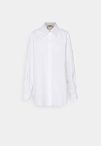 Camicia bianca con colletto ampio, maniche lunghe e taglio dritto. Realizzata in un tessuto leggero e liscio. Dettagli minimal.