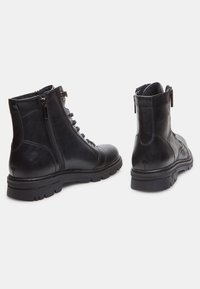 Botine din piele neagră cu vârful rotund, fermoar lateral, șireturi în față și talpă texturată pentru aderență. Detalii cusute vizibile.