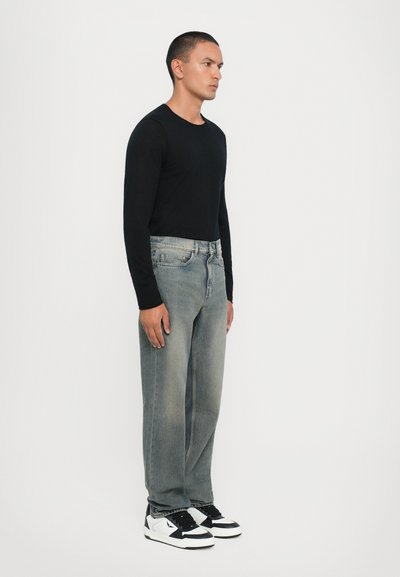 Black long-sleeve shirt, light gray straight-leg jeans, and black-and-white sneakers. Simple design, smooth texture, and regular fit.