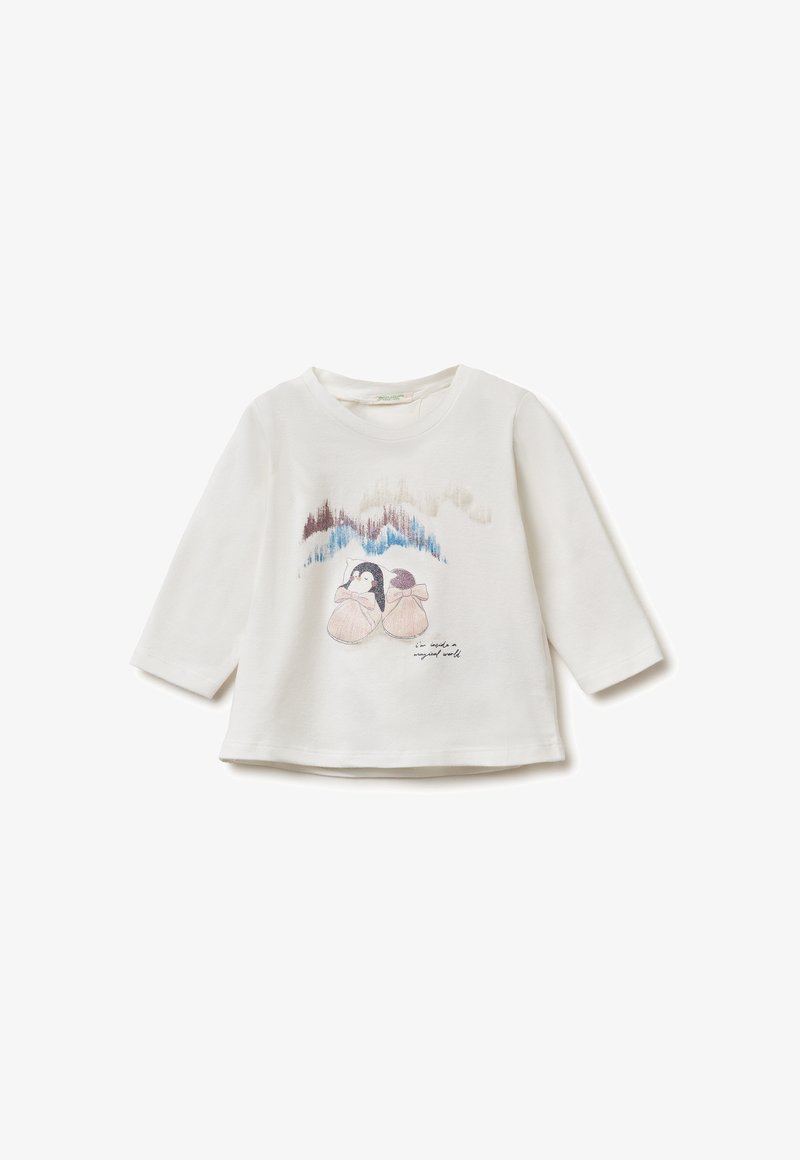 Camiseta blanca de manga larga hecha de algodón, con un diseño impreso de dos pingüinos y montañas nevadas. El texto dice "en un mundo tan mágico."