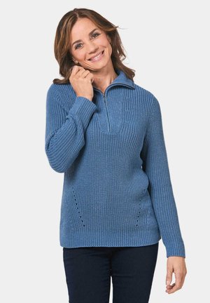 Blauer, gestrickter Pullover mit halbem Reißverschluss am Kragen, aus strukturiertem Stoff mit dezenten Seitenstich-Details. Lange Ärmel.