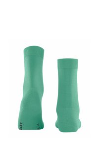 Grüne Baumwollsocken mit geripptem Bündchen, glatter Textur und leichtem Design. Seitlich präsentiert, um Form und Details zu zeigen.