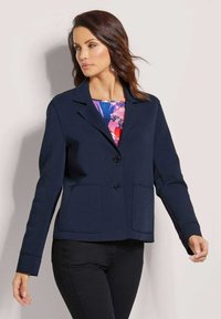 Marineblazer aus Jersey-Stoff, mit Reverskragen, zwei Fronttaschen und einem einzigen Knopfverschluss. Figurbetonter Stil mit langen Ärmeln.