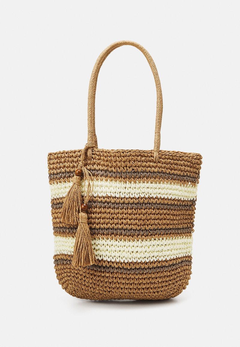 Sac fourre-tout tissé à la main avec des rayures horizontales marron, beige et crème, deux pompons avec perles en bois, et des poignées arrondies.