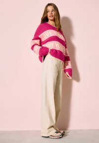Rózsaszín és krémszín csíkos pulóver "LOVE YOU" felirattal, bordázott mandzsettákkal, bézs, széles szárú nadrággal, apró szívecskékkel díszítve.