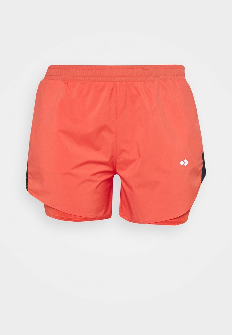 Pantalones cortos deportivos color coral con cintura elástica, con detalles laterales negros y un pequeño logo blanco en la pierna derecha.