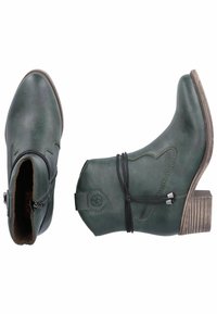 Botas de cuero verdes hasta el tobillo con punta afilada, cremallera lateral, costuras decorativas y tacón apilado. Presenta un detalle de lazo y atado en el tobillo.