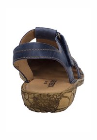 Marineblaue Ledersandale mit mehreren Riemen, einem Schnallenverschluss und einer strukturierten, hellbraunen Sohle. Das Innere hat eine glatte, beige Fütterung.