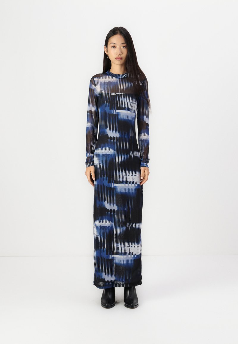 Long-sleeve maxi dress in a blue, black, and white abstract pattern. Fits close to the body with elastic cuff detail. Smooth fabric texture.