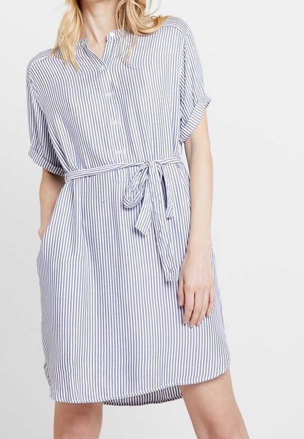 Sukienka w paski w kolorze białym i granatowym, z krótkimi rękawami, zapięciem na guziki z przodu, paskiem w talii oraz kieszeniami bocznymi. Wykonana z miękkiego materiału, luźny krój.
