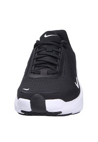 Scarpe da ginnastica nere con una parte superiore testurizzata, caratterizzate dal logo Nike bianco e lacci. La suola è bianca con accenti neri, creando un contrasto.