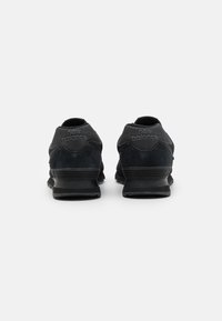 Schwarze Wildleder- und Mesh-Sneaker mit gepolstertem Kragen, strukturiertem Sohlen und "New Balance"-Logo an der Ferse, mit einem modernen Design.