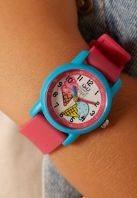 Kleurrijk horloge met een roze en blauwe siliconen band, met een ijsjesontwerp op een witte wijzerplaat met grote, duidelijke cijfers.