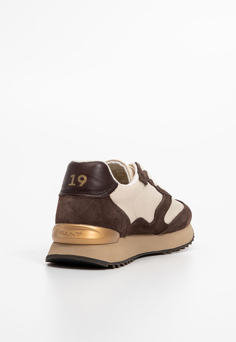 Braune und cremefarbene Sportschuh mit Wildleder- und Leder-Materialien, ausgestattet mit einem goldenen Akzent an der Ferse und der Zahl "19" an der Rückseite.