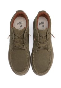 Zapatos de ante verde oliva con diseño de cordones, forro interior marrón claro, costuras decorativas en la suela y logo grabado en la lengüeta.