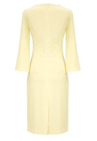 Żółta sukienka z dopasowanym korpusem, rozkloszowanymi rękawami, zapięciem na suwak z tyłu oraz rozcięciem z tyłu, wykonana z gładkiego materiału.