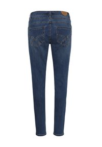 Vue de dos d'un jean slim bleu foncé avec deux poches arrière présentant des motifs cousus et une petite étiquette de marque en cuir marron.