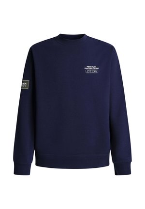 Temno modra majica z okrolim izrezom, na prsih z napisom »Red Bull Racing Team EST. 2004« in na levi rokavu našitek Red Bull Racing.