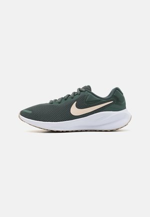 Dunkelgrüner Mesh-Laufschuh mit beigem Nike-Swoosh und dicker weißer Sohle, von der Außenseite betrachtet.