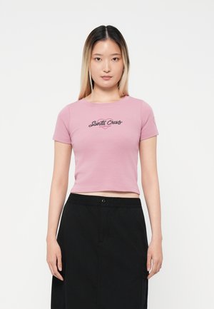 Cropped t-shirt rosa corto con una grafica nera "Santa Cruz" sul davanti, con maniche corte e scollatura rotonda.