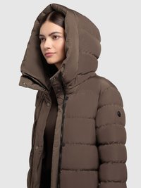 Smeđa podstavljena jakna s velikim kapuljačom, patentnim zatvaračem sprijeda, kopčama na drukere i glatkom, sjajnom teksturom. Ima prešivene šavove i bočne džepove.