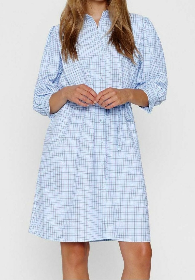 Abito camicia a scacchi blu e bianchi con bottone sul davanti, maniche lunghe, vita arricciata e orlo dritto. Tessuto dalla consistenza morbida.