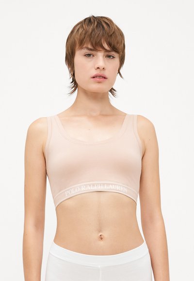 Helles rosa Sport-BH mit rundem Ausschnitt und breiten Trägern. Verfügt über ein weißes, markiertes elastisches Band am unteren Rand, hergestellt aus weichem Stoff.