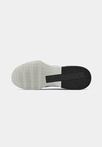 Shoe sole with textured white rubber and a black section, featuring a zigzag pattern and embossed branding for traction and support.