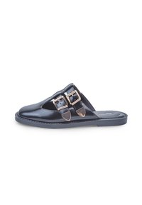 Black leather slip-on mule with pointed toe and two gold buckle straps on the upper, flat rubber sole, photographed on white background.