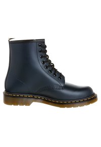 Zwarte leren veterschoenen met een ronde neus, gele stiksels langs de zool en een patroon op een doorschijnende rubberen zool.