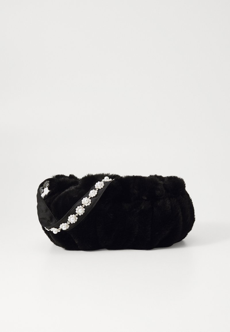 Bolsa de mão preta em pelúcia com um design acolchoado, apresentando uma alça de cetim decorada com detalhes semelhantes a pérolas. Textura macia com forma arredondada.