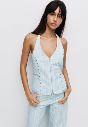 Top halter azzurro chiaro con zip, caratterizzato da un motivo a righe verticali, dettagli in metallo argentato lungo la parte frontale e una silhouette aderente.