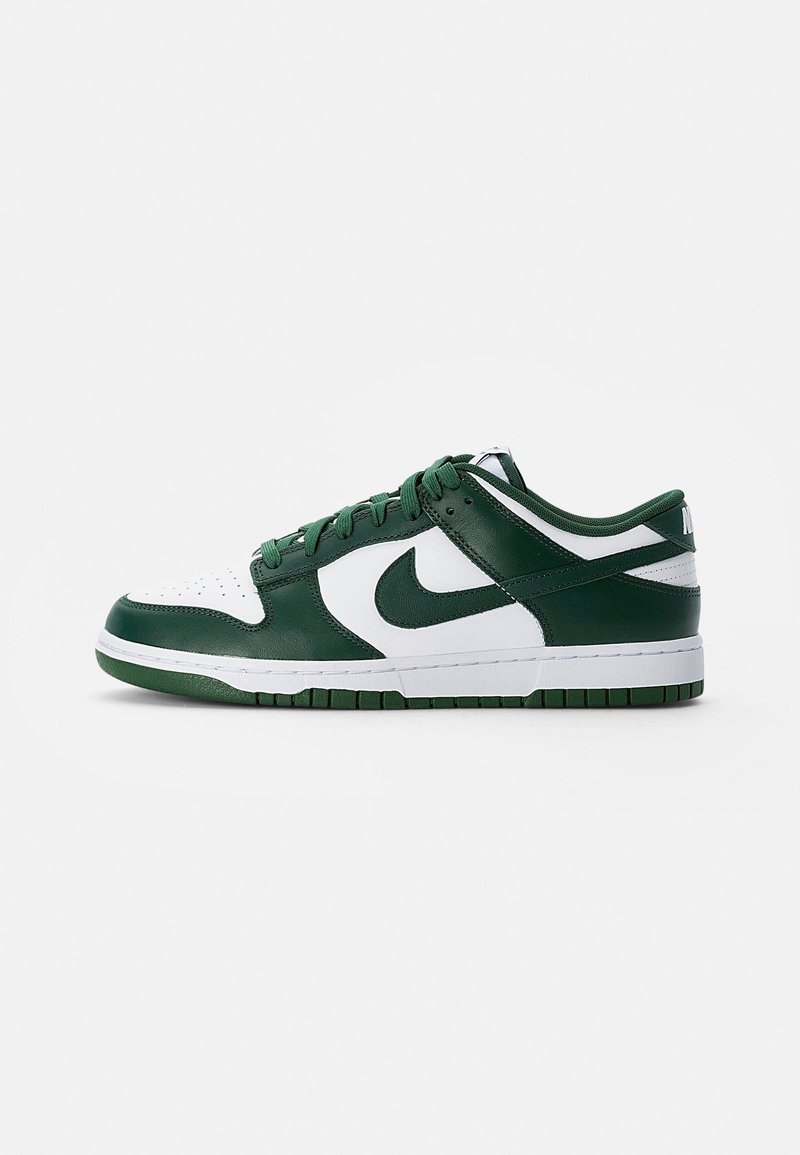 Nike Dunk Low sneakers feature a green leather upper with white accents, a perforated toe, and a rubber outsole in matching green.