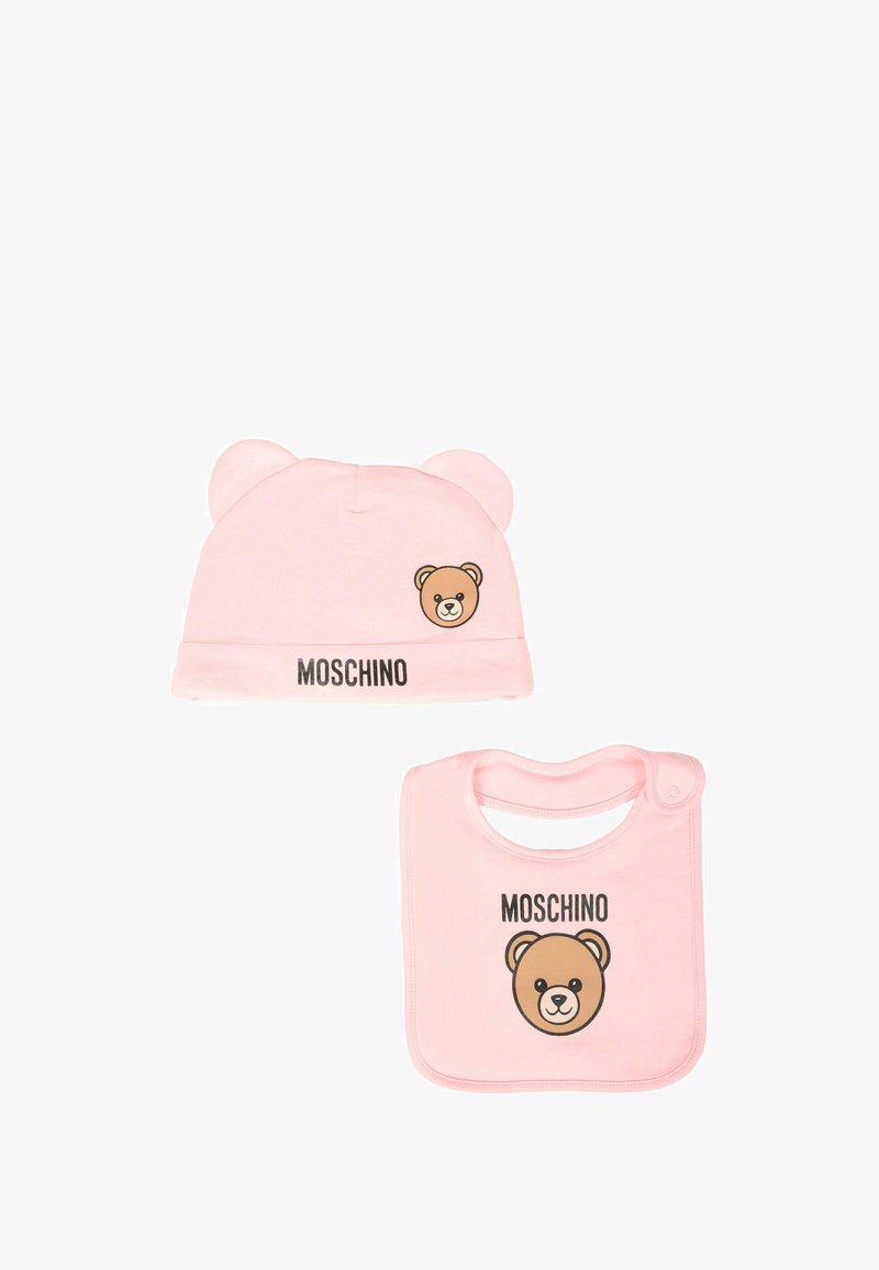 Gorra de algodón rosa con orejas de oso y cara de oso impresa; babero a juego con cara de oso y logotipo. Textura suave, forma redondeada y diseño apto para niños.