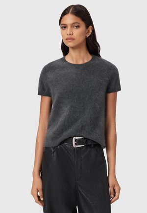 Mørkegrå kortærmet sweater lavet af blødt, fuzzy materiale; rund halsudskæring; båret over sorte faux læder højtaljede bukser med en sølv spænde.